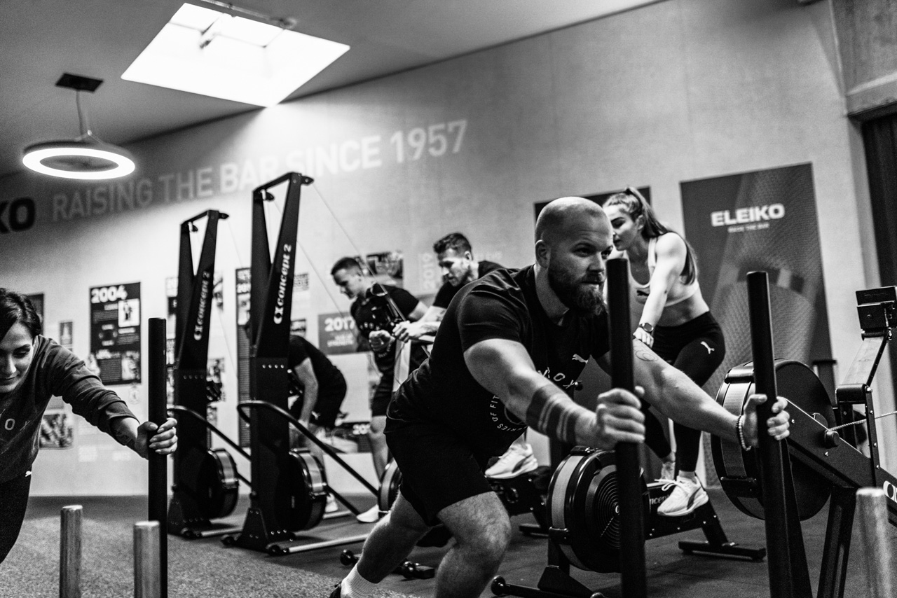 HYROX-Athlet:innen bei verschiedenen Wettkampfstationen wie Sled Push, Wall Balls und SkiErg – in Aktion und voller Fokus.