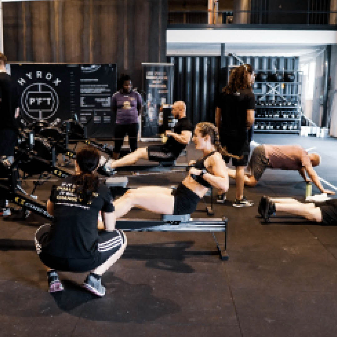 HYROX-Training mit Rudergeräten – Athlet:innen in einer intensiven Trainingsphase.