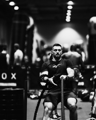 HYROX-Athlet beim intensiven Sled Pull während des Wettkampfs, Fokus auf Technik und Kraft.